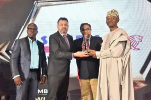 L to R: Taiwo Akinpelu, Mahendra Pratap and Pankaj Chopra receiving the best automobile company of the year award (2 wheeler and 3 wheeler) from BusinessDay Publisher, Frank Aigbogun